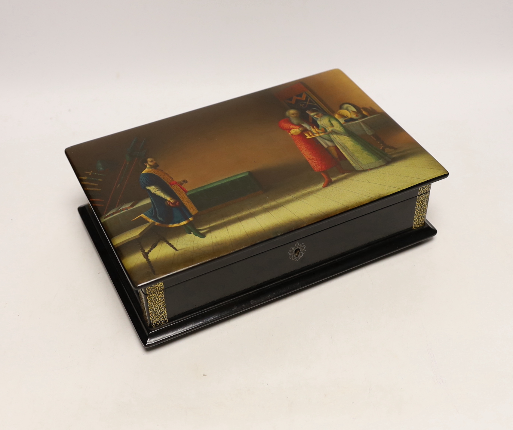 A large Russian lacquer box, by Lukutin, pre-1917, painted with a nobleman and guest in an interior, 26cm, Please note this lot attracts an additional import tax of 5% on the hammer price
